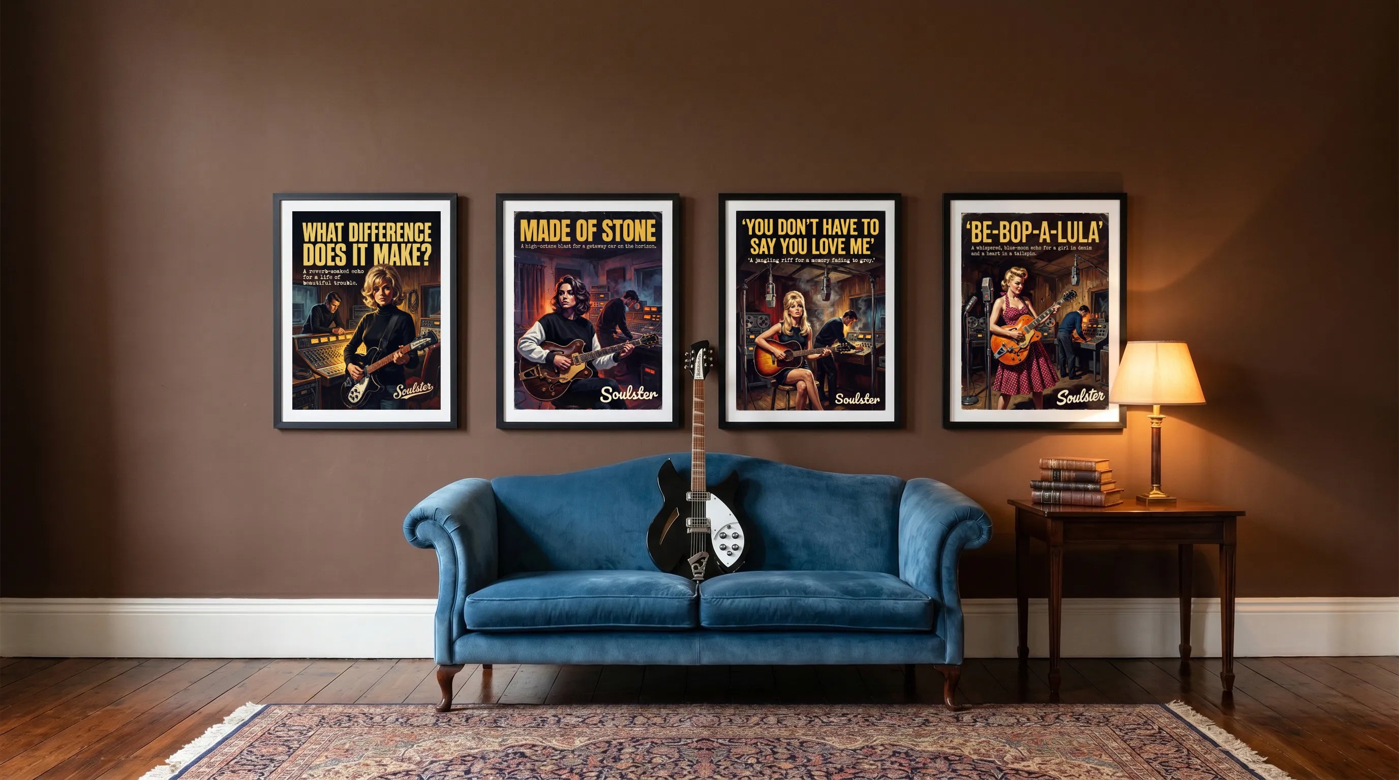 Four framed music posters displayed on a brown wall above a blue velvet sofa in a styled living room setting.
